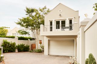 Front view of a modern contemporary home with a garage and large balcony