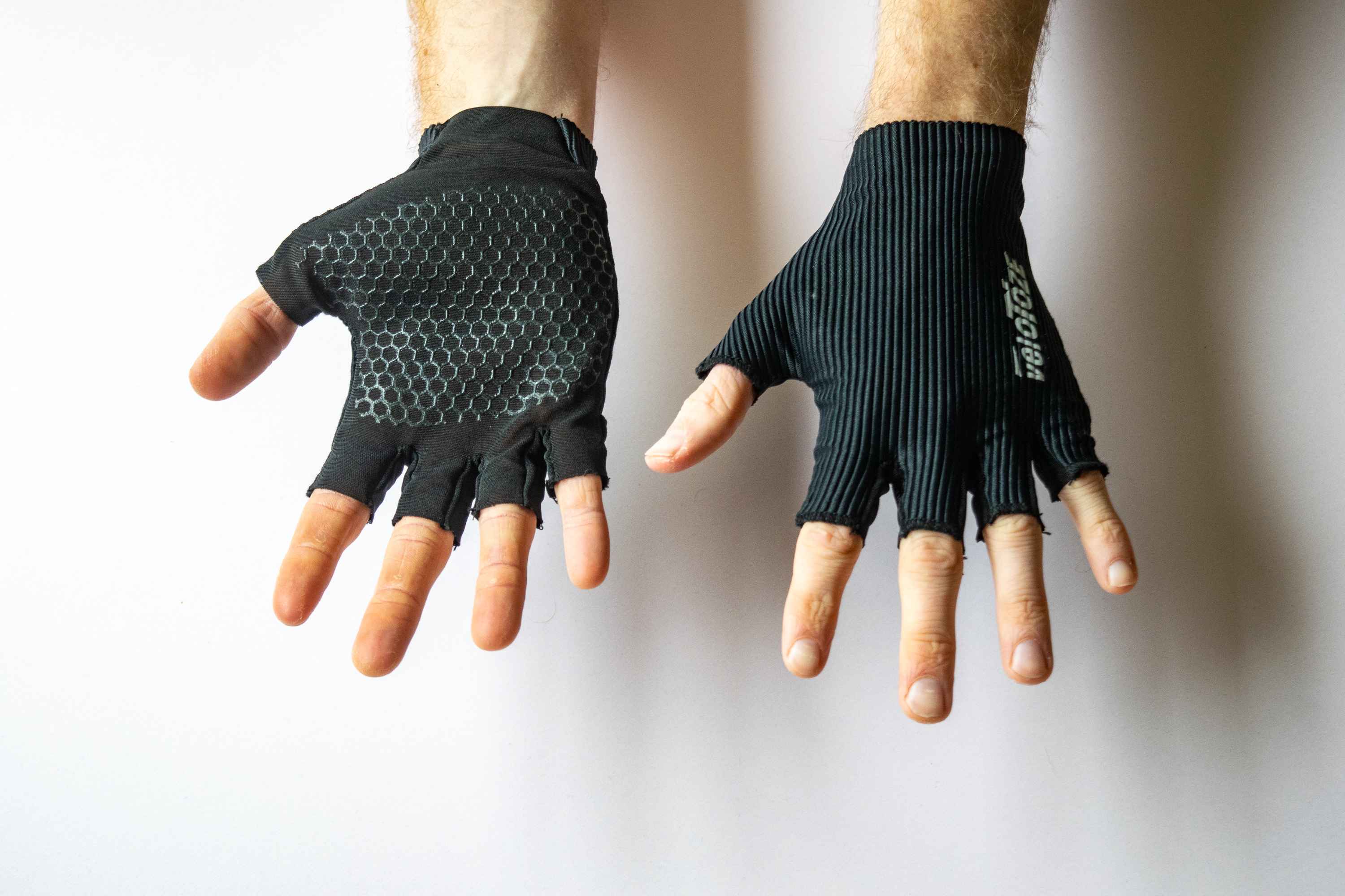 A rider wearing Velotoze Featherweight Gloves with hands showing the palm and face of the gloves