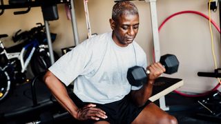 Man doing a bicep curl with a dumbbell to get the benefits of exercise over 50