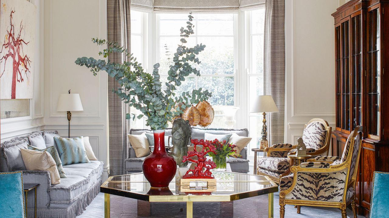 main neutral living room with gilded, patterned chairs, gray sofa and blue armchairs in Edwardian house in West London designed by Philip Vergeylen of Nicholas Haslam