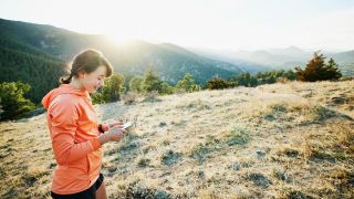 Trail runner looks at phone