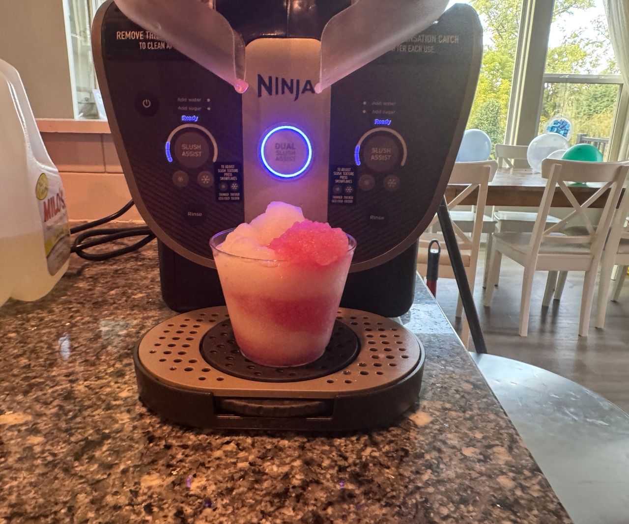 A pink and white drink on the drip tray of the Ninja Slushi Twist