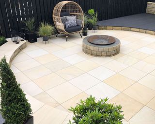 round patio with stone paving and modern hanging chair