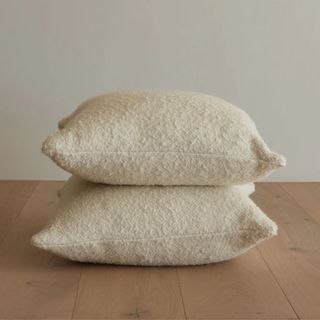 Two Jenni Kayne Nell Boucle Pillows on a wooden floor