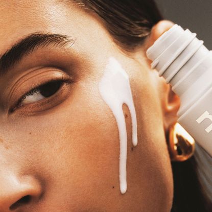 An image showing a woman applying the Rhode Glazing Milk