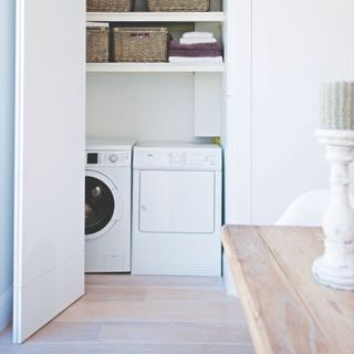 Utility room cupboard with washing machine, dryer, and shelving