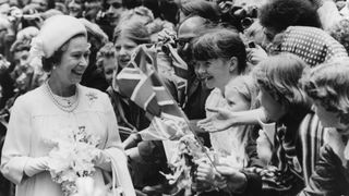 1977: Queen Elizabeth II laughing with a crowd of children during celebrations for her Silver Jubilee.