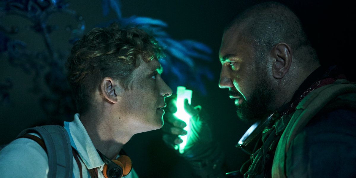 Army of the Dead Matthias Schweighöfer and Dave Bautista stand face to face, with glow sticks