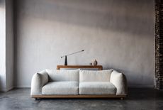 a white sofa in front of a side table in an industrial room