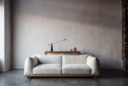 a white sofa in front of a side table in an industrial room