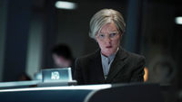 a woman in front of a mission control monitor