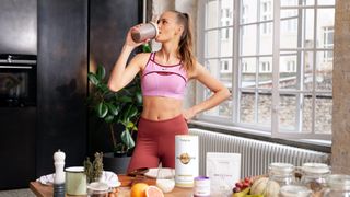fit athletic women drinking a protein shake out of a shaker bottle