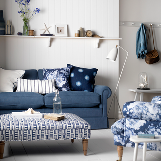 Living room with blue and white decor, blue sofa and cushions