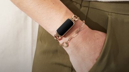 Woman with hand in her pocket wearing Fitbit gorjana design smart watch