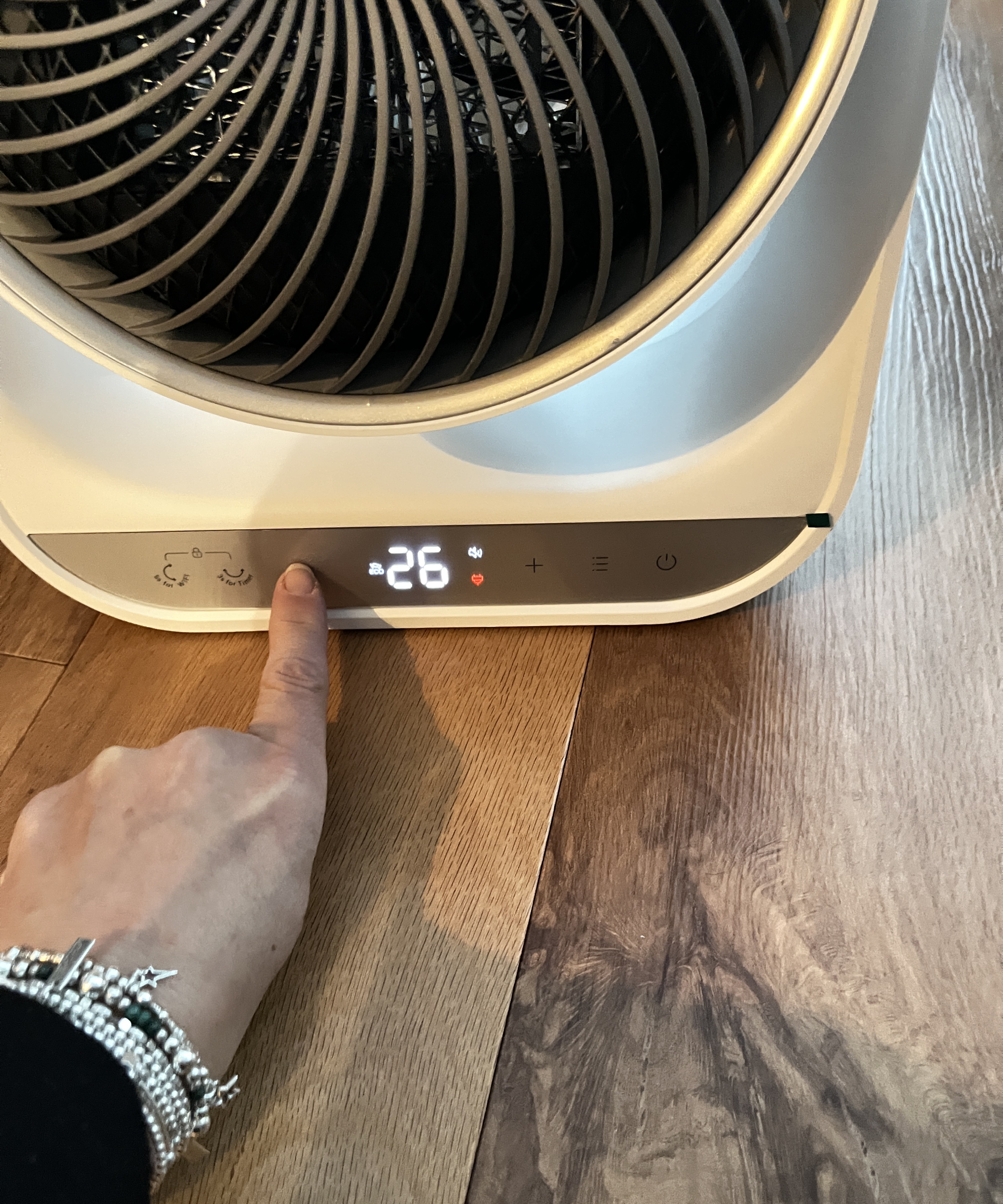 hand pressing front control panel of Dreo heater