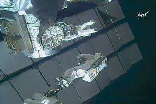 During their spacewalk together on Feb. 16, 2018, NASA astronaut Mark Vande Hei “stands” on a portable foot restraint while JAXA astronaut Norishige Kanai floats by the Quest airlock.