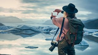 Female photographer at glacier lagoon at sunse
