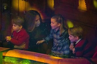 Britain's Catherine, Duchess of Cambridge (2nd L) holds Britain's Prince Louis of Cambridge (L) as she speaks with Britain's Princess Charlotte of Cambridge (2nd R) and Britain's Prince George of Cambridge (R) at a special pantomime performance of The National Lotterys Pantoland at London's Palladium Theatre in London on December 11, 2020, to thank key workers and their families for their efforts throughout the pandemic. (Photo by Aaron Chown / POOL / AFP) (Photo by AARON CHOWN/POOL/AFP via Getty Images)