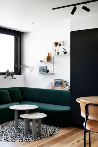 small white living room with built in green banquette