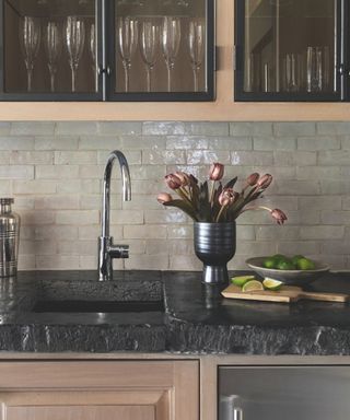 kitchen detail with grey gloss tiles and black marble work top