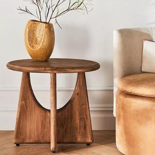 A mid-century modern, wooden side table with a small vase