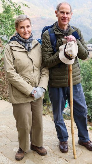 Duchess Sophie wearing beige/sand outdoors co ord trousers and coat with brown walking boots, fingerless gloves and scarf