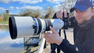 Mike Harris holding OM System OM-1 Mark II in green space