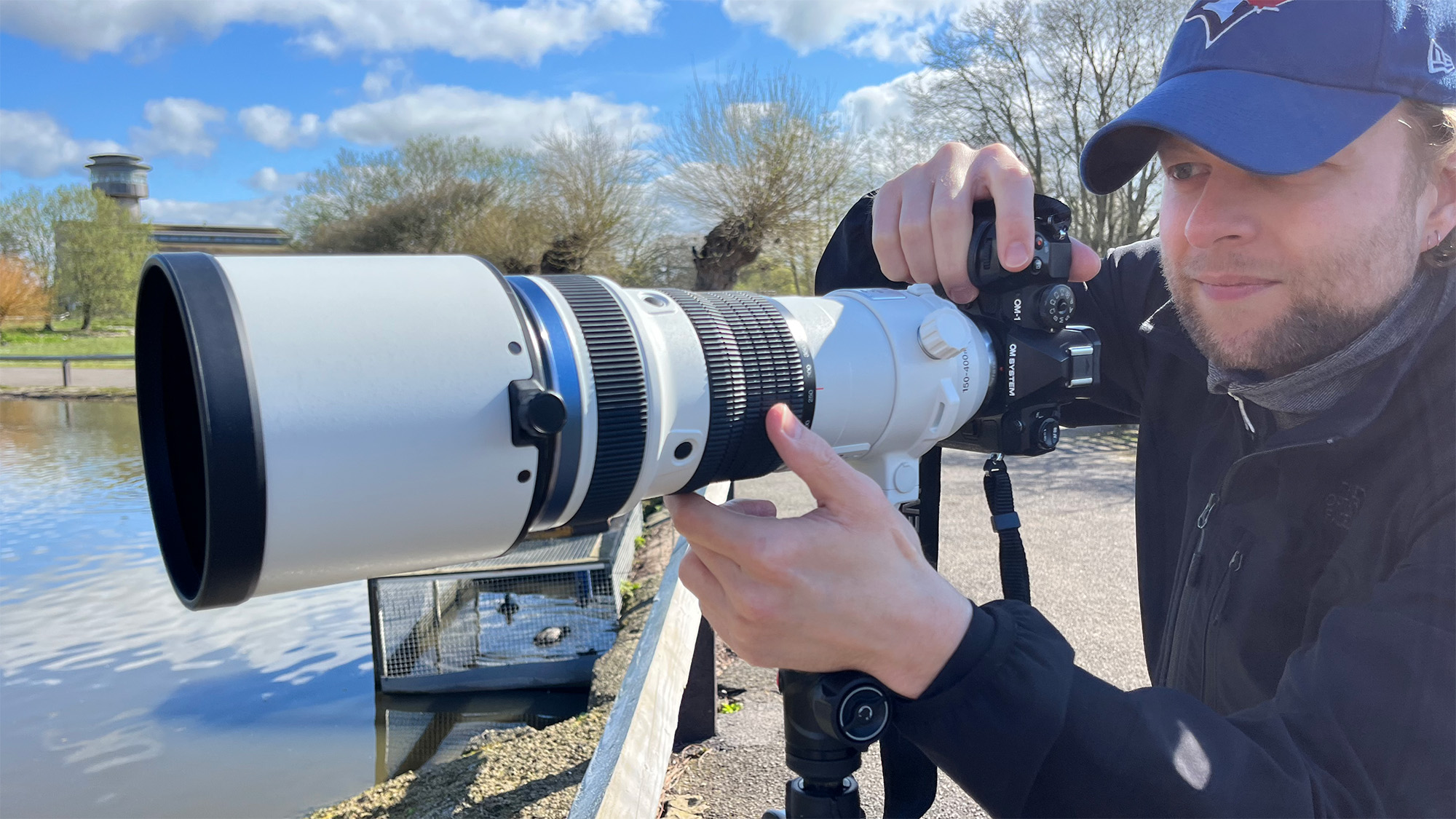 Mike Harris holding OM System OM-1 Mark II in green space