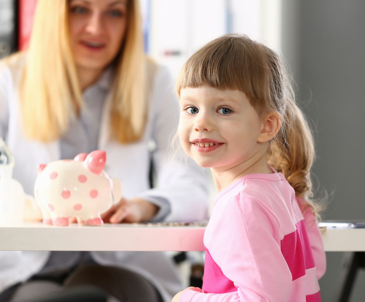 Mum and child with piggy bank