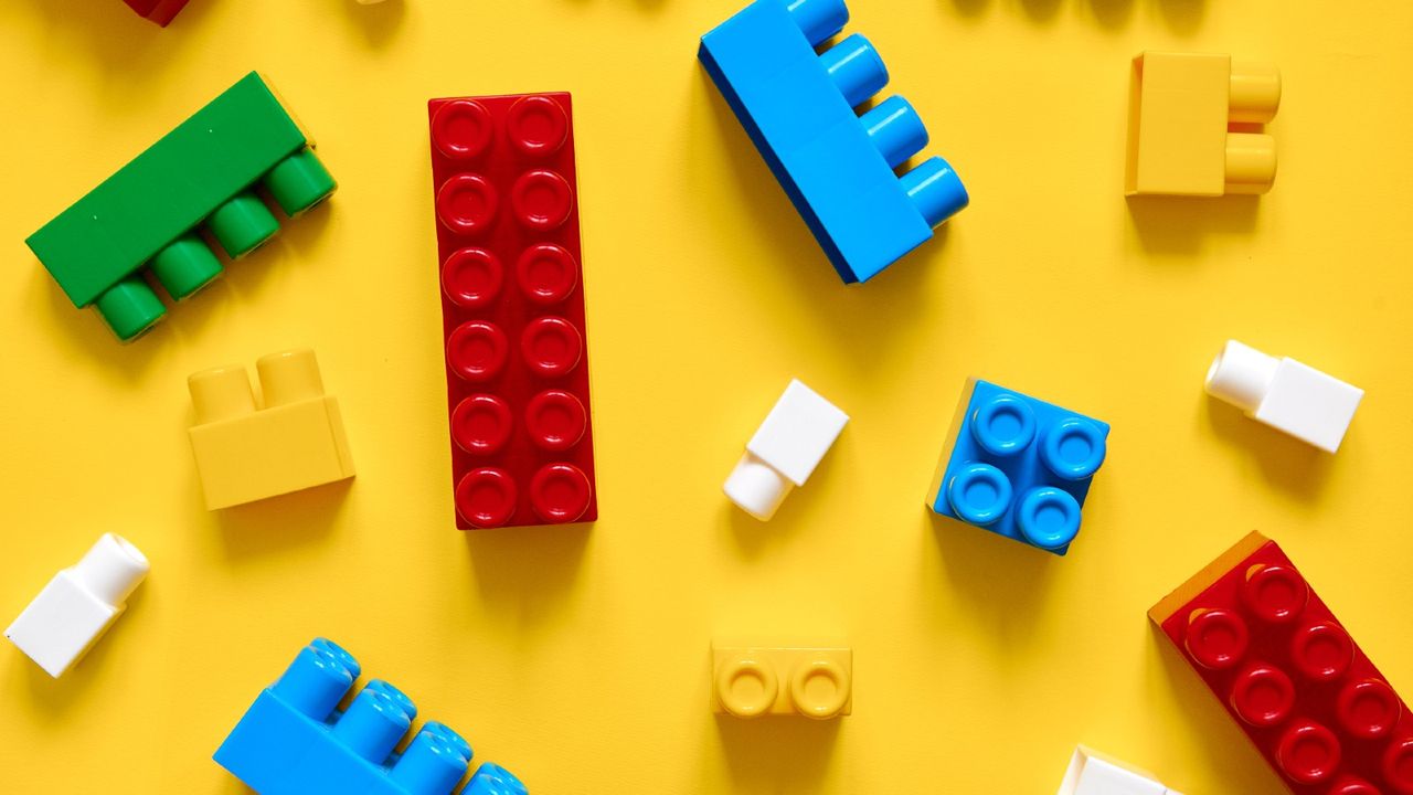 Directly Above Shot Of Colorful Toy Blocks On Yellow Background - stock photo