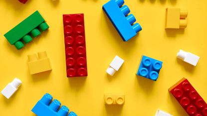 Directly Above Shot Of Colorful Toy Blocks On Yellow Background - stock photo