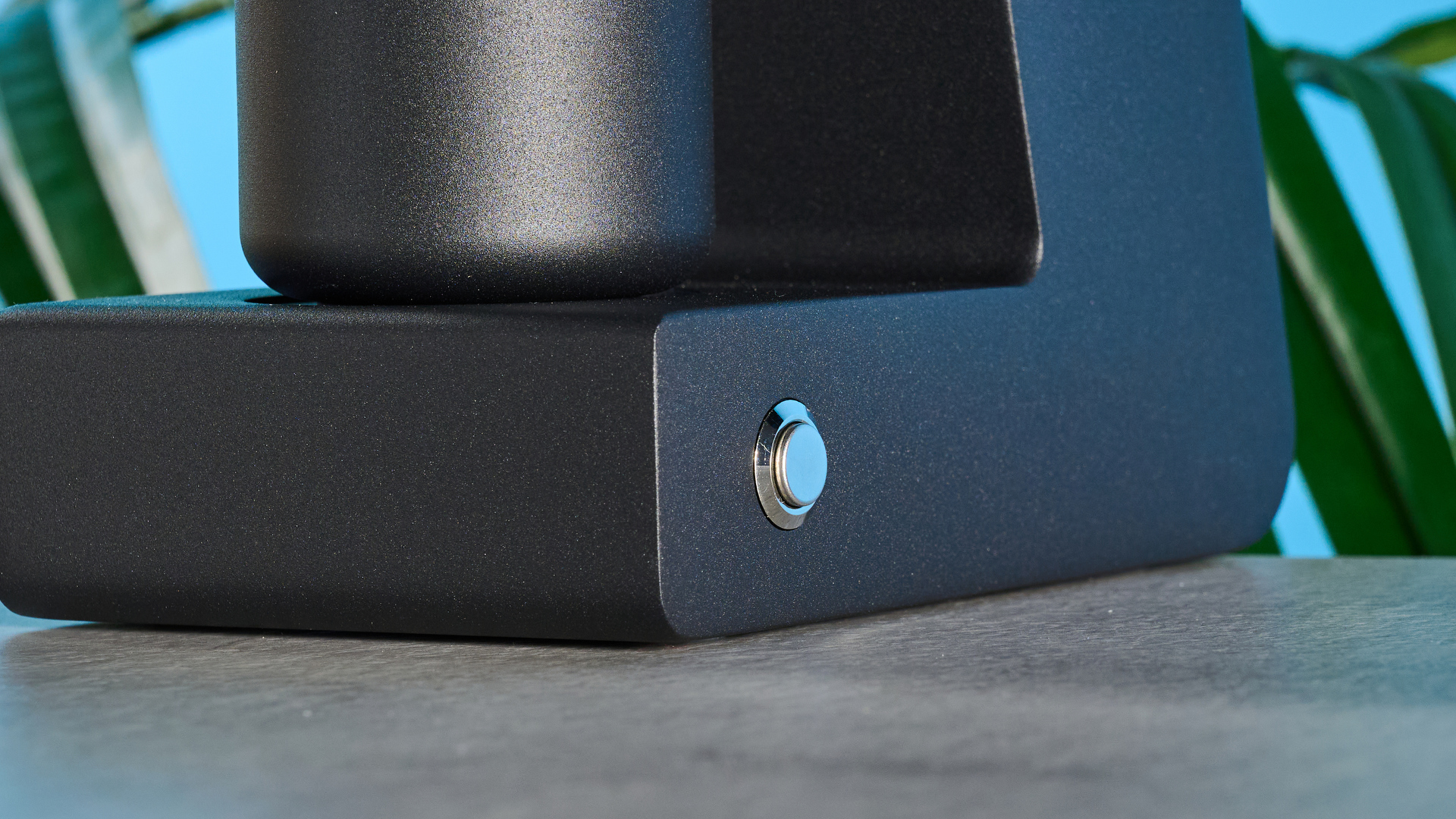 The Varia VS3 coffee grinder in use on a stone surface with a blue background