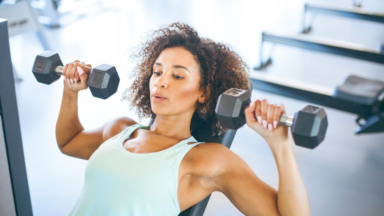 Woman trains her upper body using a set of dumbbells