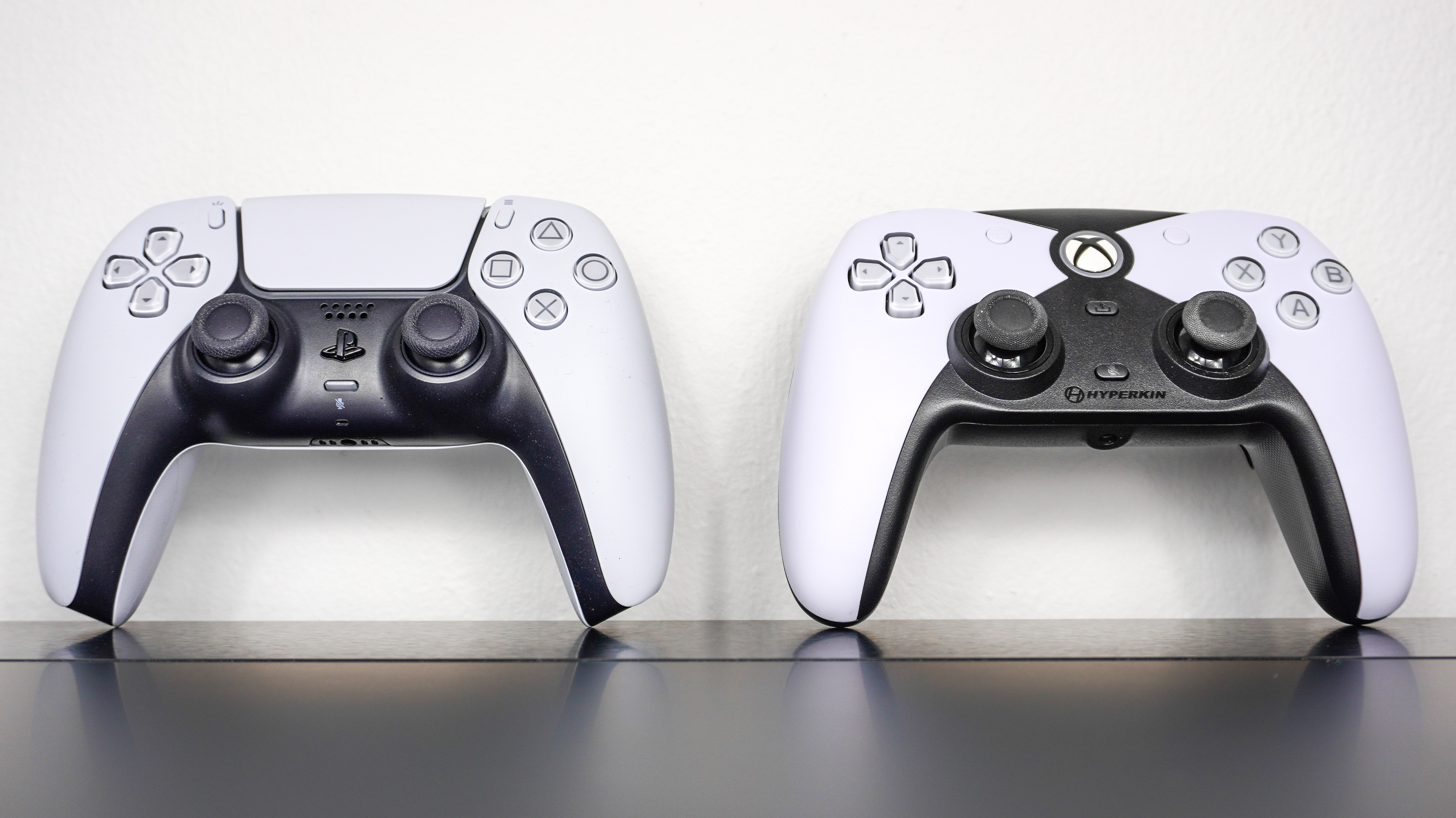 The Hyperkin Competitor side by side with Sony's DualSense controller on a desk