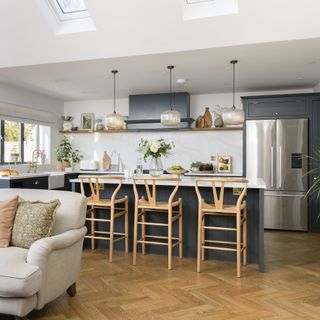 Navy kitchen with warm herringbone flooring