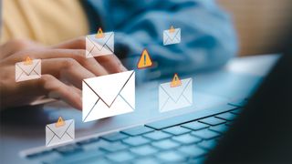 A person types on a laptop keyboard with envelope and warning icons hovering above, indicating email security threats