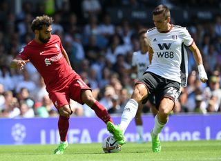 Mohamed Salah of Liverpool is challenged by Joao Palhinha of Fulham during the Premier League match between Fulham FC and Liverpool FC at Craven Cottage on August 06, 2022 in London, England.
