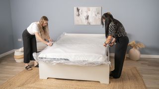 Two mattress testers for Toms guide cutting the plastic off the Nectar Luxe mattress