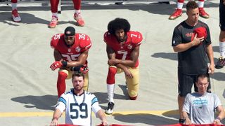 Colin Kaepernick, right, and team-mate Eric Reid kneel during the national anthem at a recent NFL game