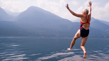 woman jumping into lake 
