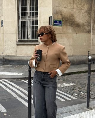 A French woman wearing a cropped jacket with jeans.