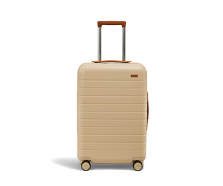 A beige plastic and leather carry on.