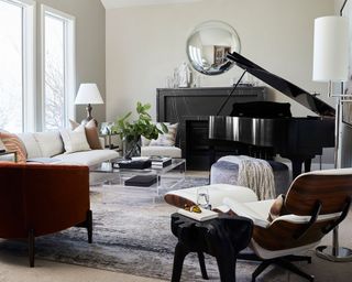 large living room with piano, lots of seating, round mirror on wall