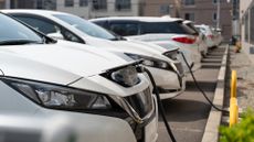 a row of electric cars parked at a charging station