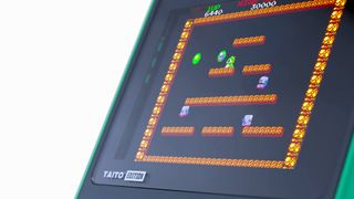 Close up of green Super Pocket console with Bubble Bobble on screen