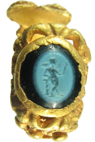 an ancient gold ring with a stone showing Cupid