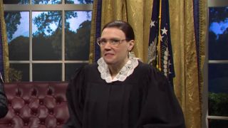 Kate McKinnon dressed as Ruth Bader Ginsburg in her Supreme Court robe.