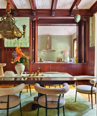 dining space with wood paneling upholstered chairs and serving hatch