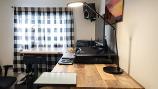 A desk lamp shining on the Vari L-Shape Electric Standing Desk