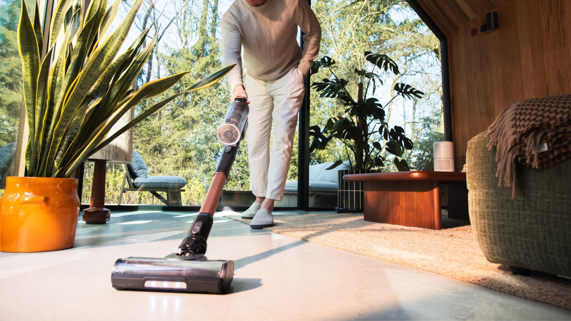 picture of man using Levoit LVAC300 stick vacuum in home